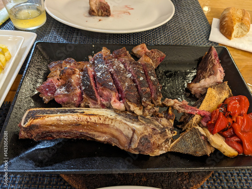 A juicy, cooked ribeye steak seasoned with salt, served with roasted vegetables, ready to enjoy.