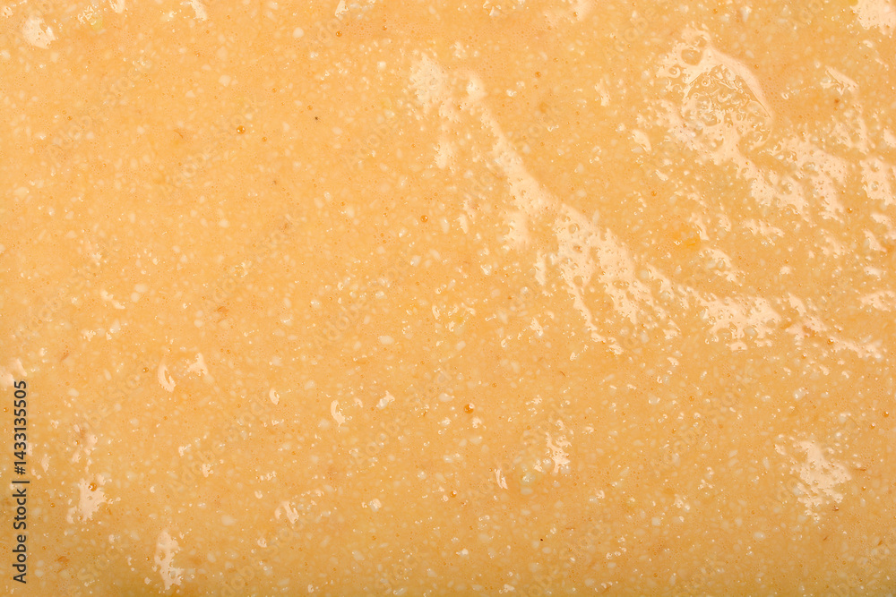 A textured, pale yellow mixture of eggs and semolina is shown in a detailed close-up, ready to be formed into dumplings for soup