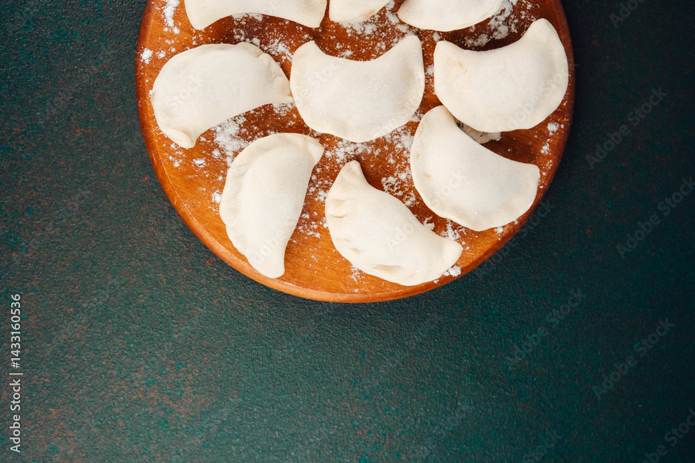 Handmade dumplings arranged on a wooden board ready for cooking