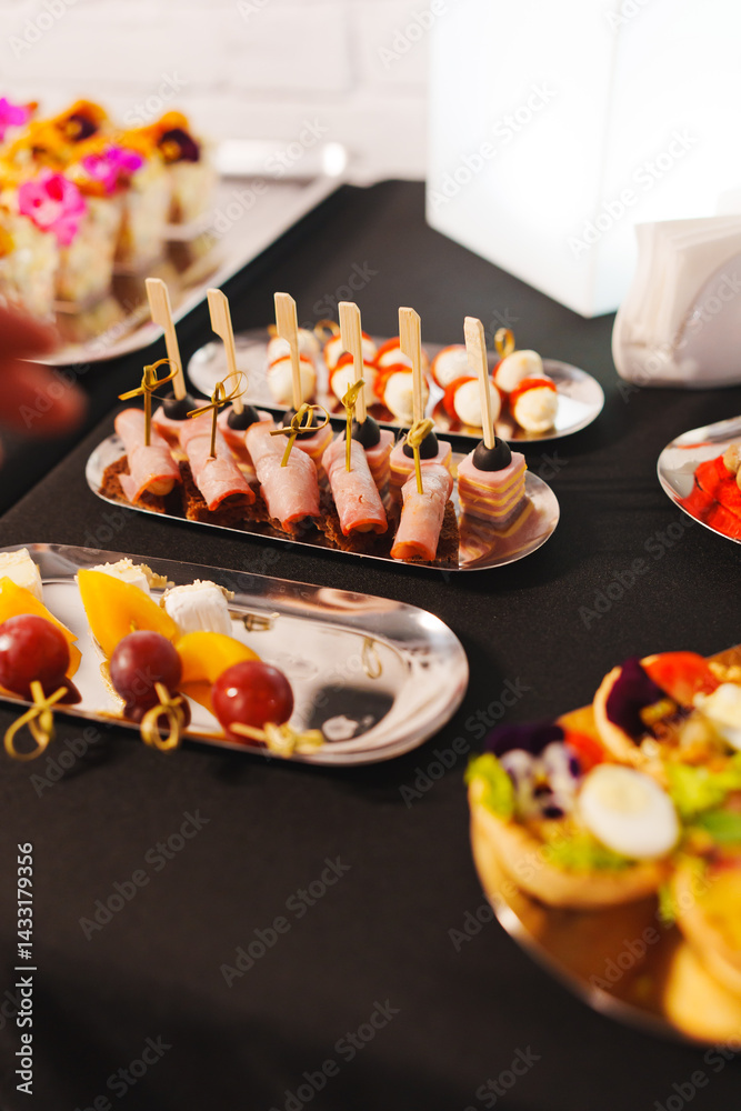 Assorted canapes on metal trays. Delicious appetizers for a buffet.