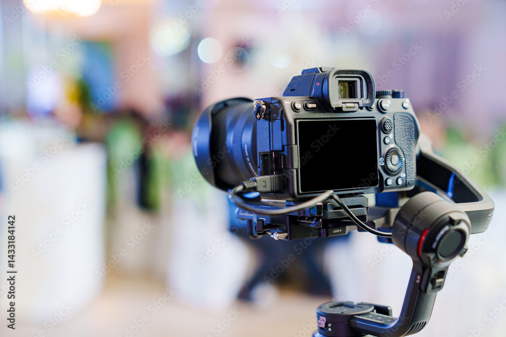 A professional camera on the blurred background of a banquet hall.
