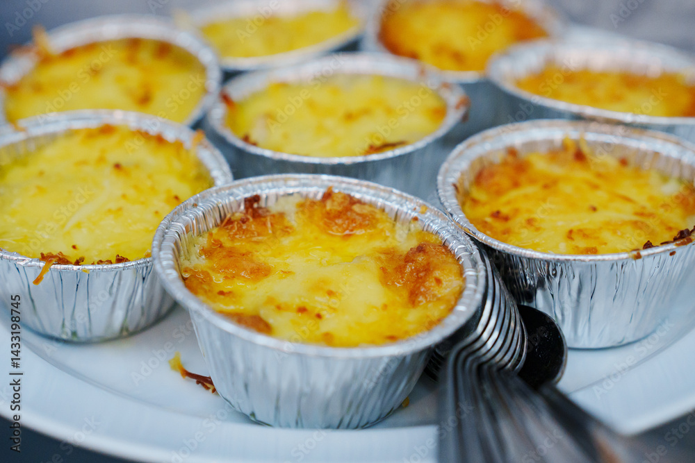 julienne with mushrooms and cheese in disposable molds for a buffet.