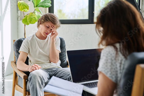 Obraz na płótnie Sad teenage boy in mental therapy session, talking with behavioral psychologist w salonie