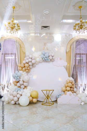 Round white background decorated with balloons and cake table. 
