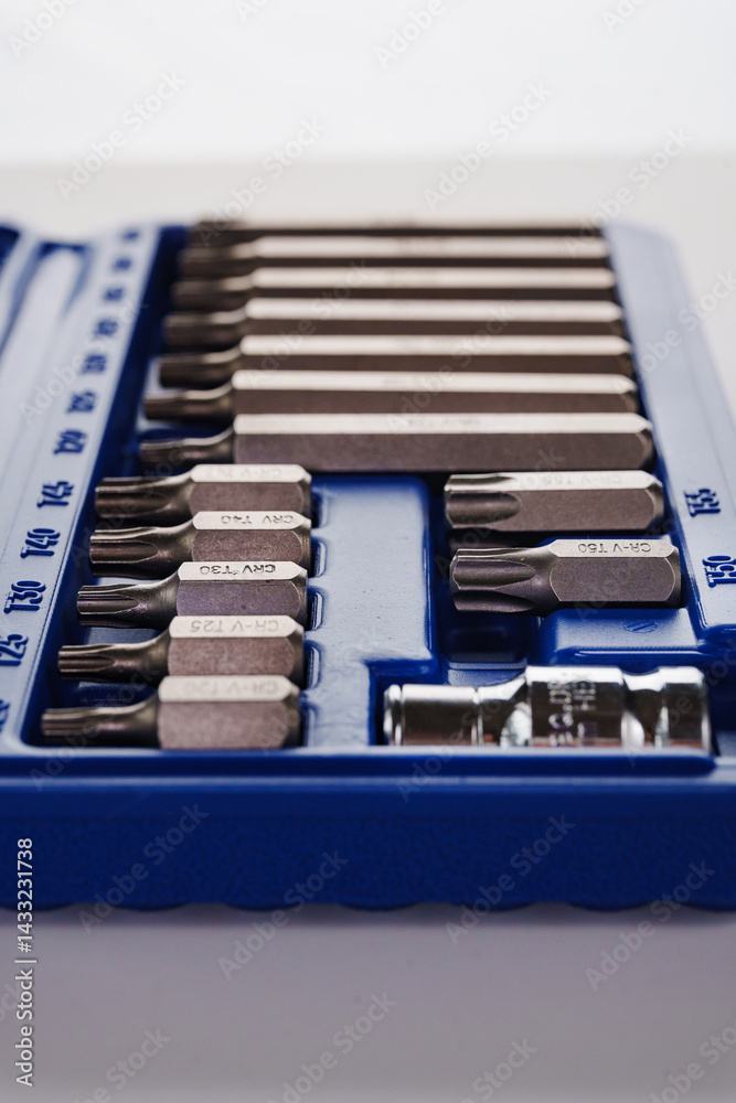 A set of single-sided chrome steel bits in a blue plastic box