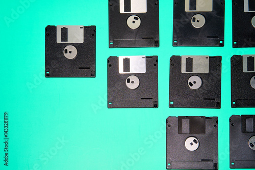 A collection of old floppy disks, relics of 90s computing, arranged in a grid on a turquoise background