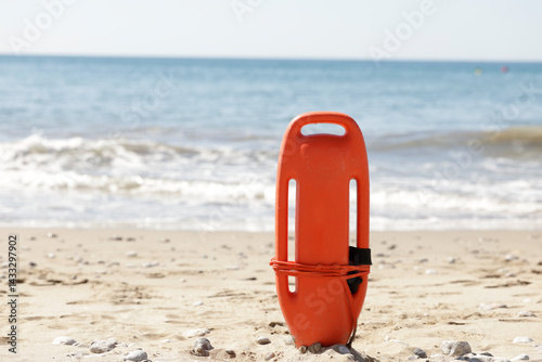 Fotografie Rescue can on the beach sand, ready for emergencies with tourists on their vacations and enjoying the summer days