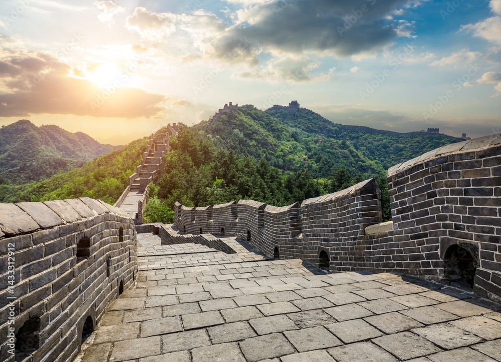 The great wall of china winding through green hills during sunset