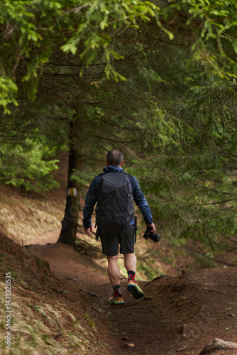 Obraz na płótnie Man descending a forest trail in hiking gear w salonie