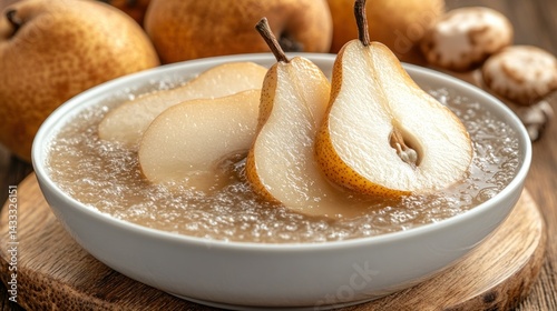 Sliced pears in a bowl of liquid.  Fresh pears, halved and sliced, gently bobbing in a clear liquid.  Aromatic and ready for consumption
