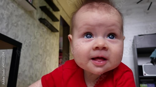 A Four-Month-Old Girl Is Looking Into The Camera Lens And Smiles
