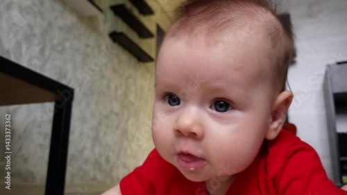 A Four-Month-Old Girl Is Looking Into The Camera Lens And Smiles