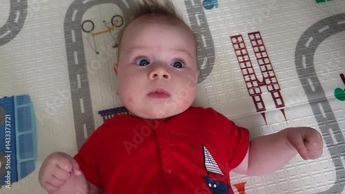 A Four-Month-Old Girl Looks Is Surprised While Lying On Her Back