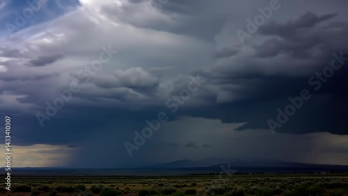 Dramatic Storm Clouds Over a Rural Landscape with Distant Mountains