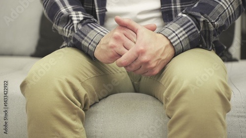 Male hands expressing fear and anxiety. Man sitting on the sofa. Slow motion photo