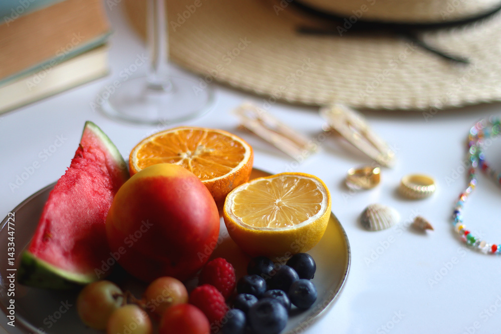 Glass of cocktail, straw hat, sunglasses, books, fresh fruit, chocolate and accessories. Summer essentials on the table. Selective focus.