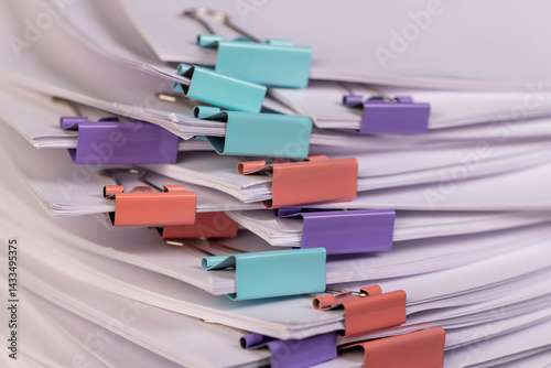 Obraz na płótnie paper are connected by multicolored metal clips, stacked sheets of paper for documents are joined together, the number of sheets of paper is different in each clip w salonie