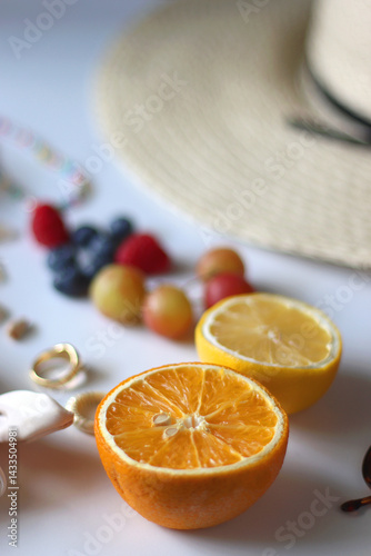 Straw hat, sunglasses, seasonal fruit, seashells and colorful accessories on white backgrounds. Cute summer essentials. Selective focus.
