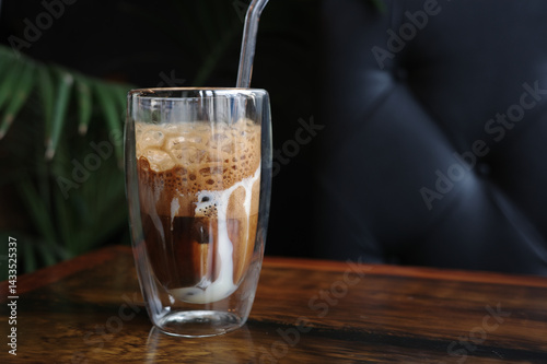 Traditional Vietnamese egg coffee with condensed milk and creamy foam on wooden table in a glass, copy space. Concept of enjoying unique Asian beverage, sweet flavor, and cultural coffee experience.