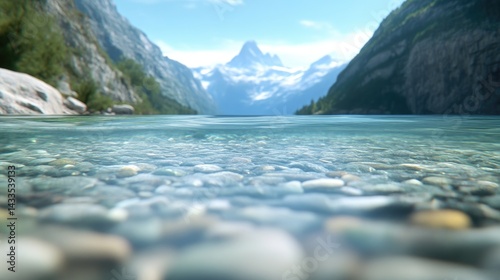 Crystal-clear alpine lake with rocky bottom and snow-capped mountains