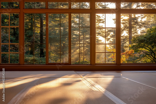 Traditional dojo interior featuring tatami mats and natural light from large windows during sunset