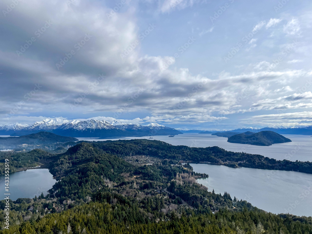 Beautiful range of snowy mountains and a lake with blue sky above in Bariloche Argentina, amazing panoramic view at Circuito Chico Patagonia.