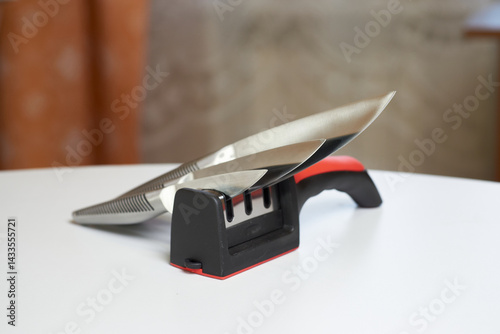 Knife sharpener and sharpened kitchen knives on the table