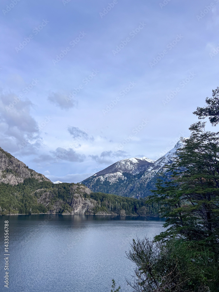 Beautiful range of snowy mountains and a lake with blue sky above in Bariloche Argentina, amazing panoramic view at Circuito Chico Patagonia.