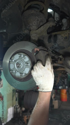 Auto mechanic installs brake caliper. Car brake system repair.