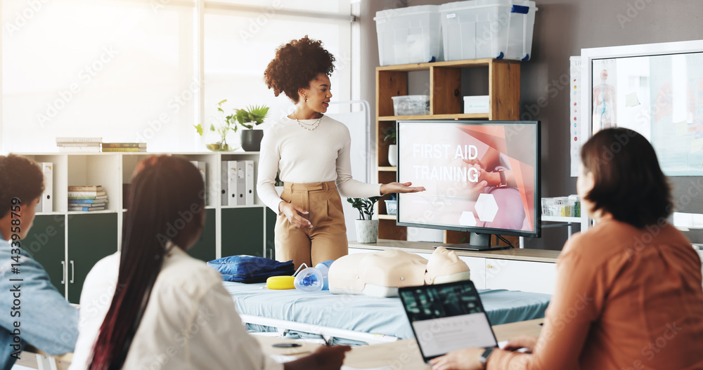 Woman, paramedic or presentation with screen for first aid training, emergency service or health and safety. Female person, teacher or students with display for medical course or rescue demonstration