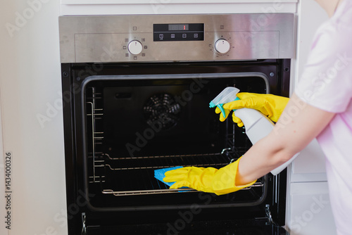 Cropped hands of woman cleaning oven at home