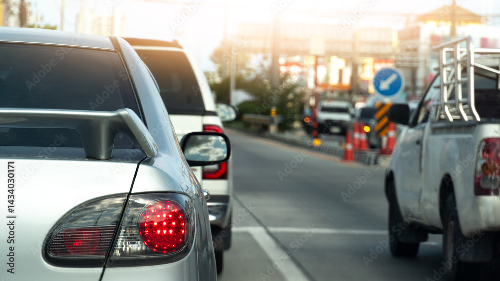 Rear side of sedan car silver color. Turn on brake light. Cars are stopped at traffic lights at intersections. Background of traffic in the city. Rear side of sedan car silver color. Turn on brake light. Cars are stopped at traffic lights at intersections. Background of traffic in the city.