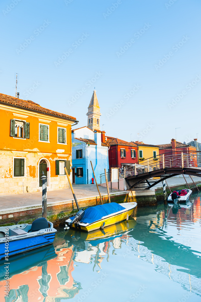 Colorful architecture in Burano island, Venice, Italy. Boats on the canal.