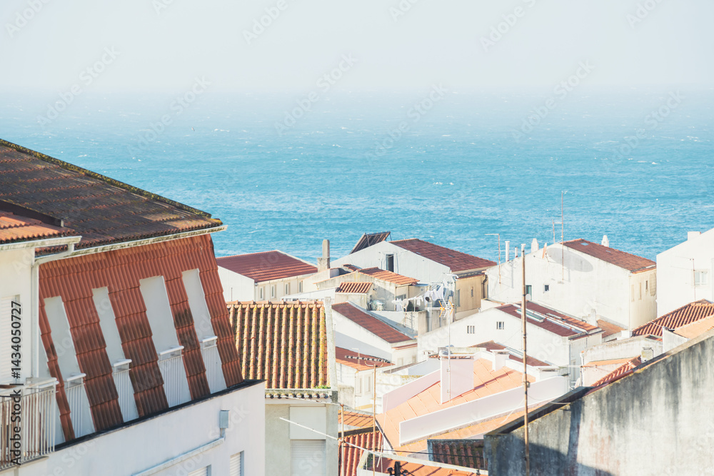 Traditional architecture with red tile roofs on the coast of Atlantic ocean in Nazare, Portugal.