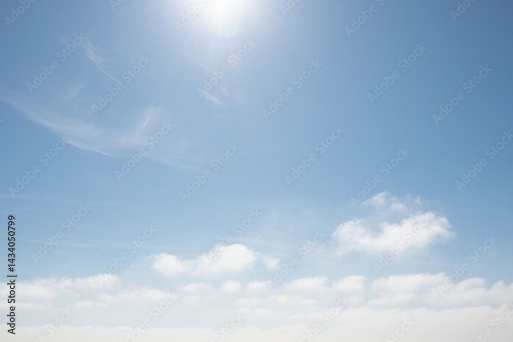 Blue sky with white clouds and sun with sunbeams at sunny day. Abstract nature background.