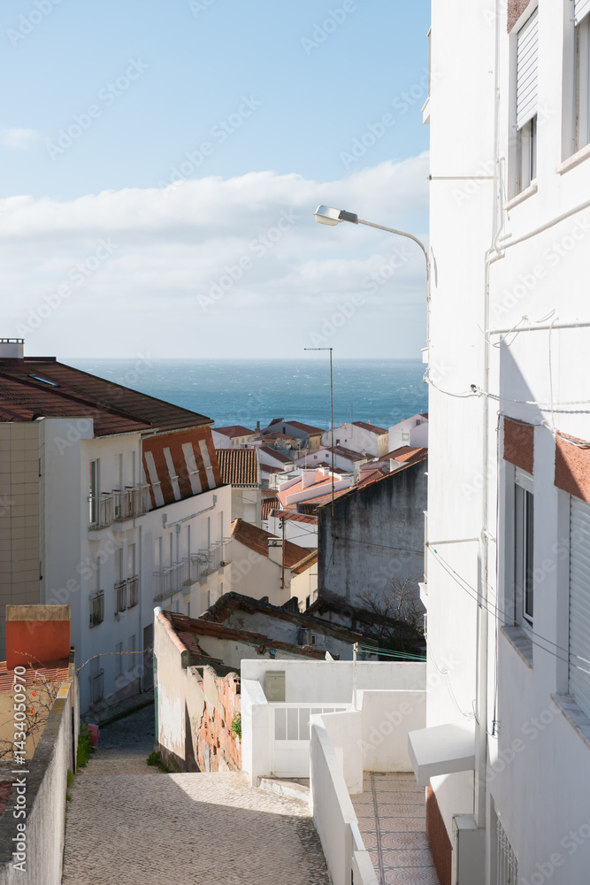 Traditional architecture on the coast of Atlantic ocean in Nazare, Portugal. View of the beach and ocean in the background