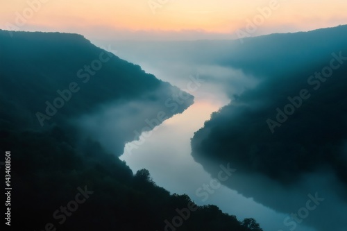 Breathtaking aerial view of a winding river cutting through a fog filled canyon at sunrise, creating a mystical and serene atmosphere