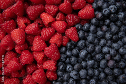 Blueberries and raspberries as a background. Top view.