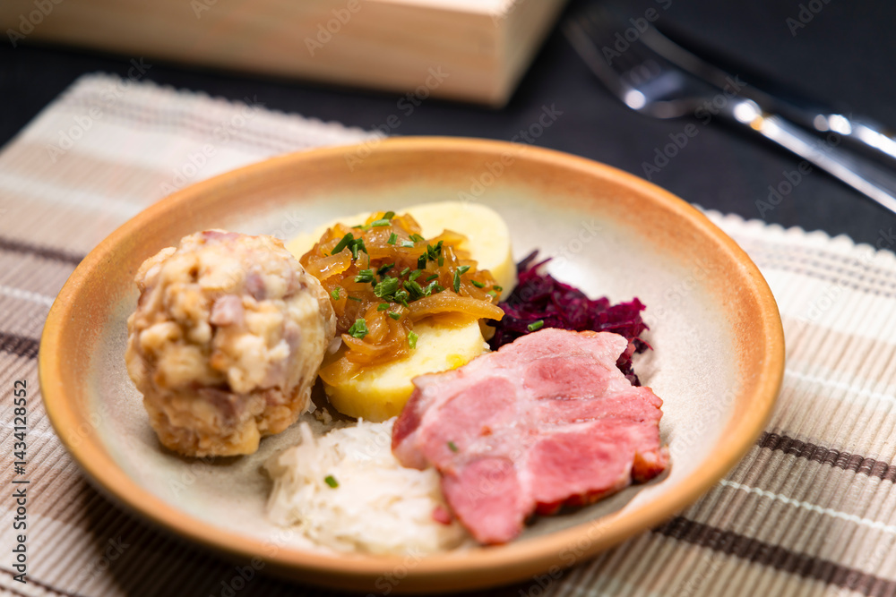 Bavarian dumplings with roasted pork, sauerkraut and potato dumpling lying on a plate