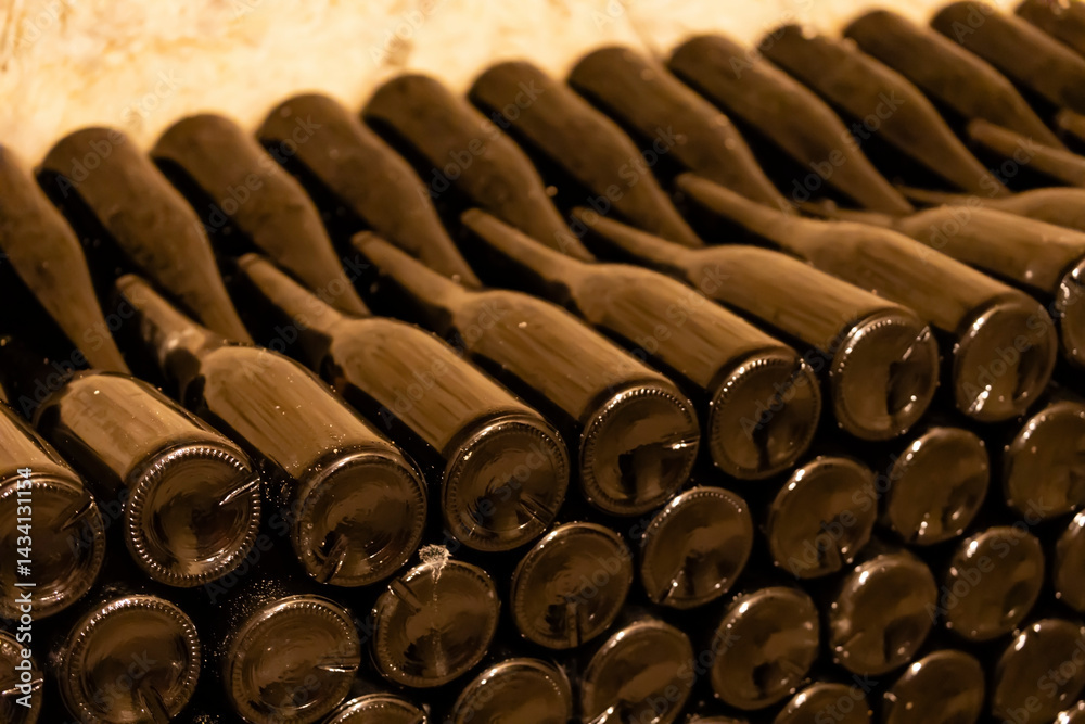 Wine bottles aging in cellar, stacked and waiting for perfect moment