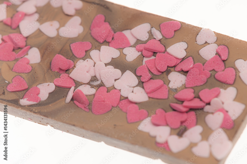 Milk chocolate bar covered with small pink and white sugar hearts