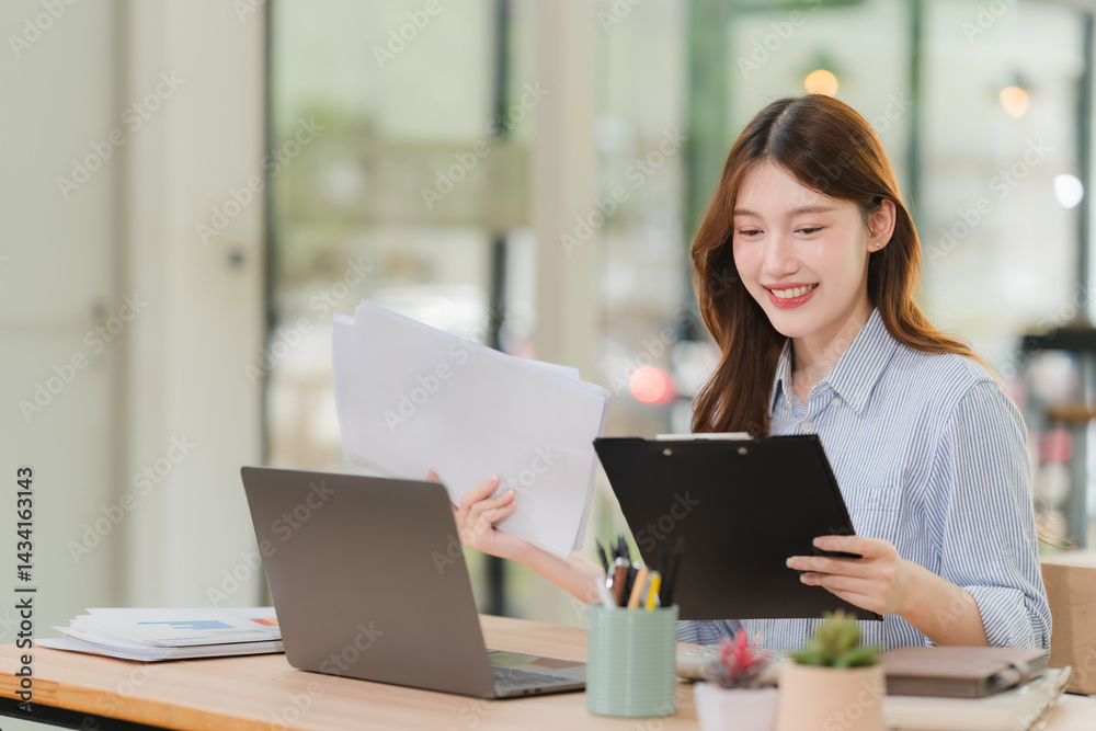 Smiling Young Woman Working with Documents and Laptop Smiling Young Woman Working with Documents and Laptop
