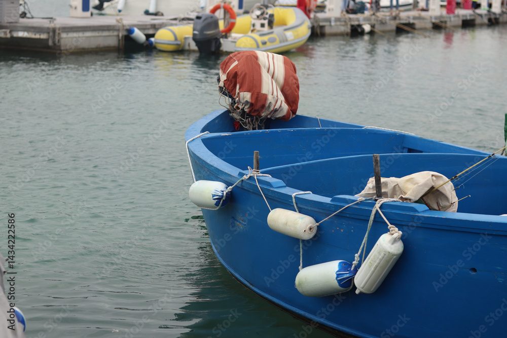Boats moored to the pier. Details. Small boats on the water, close-up. Summer sunny day on the pier. Old boats. Vacation at sea