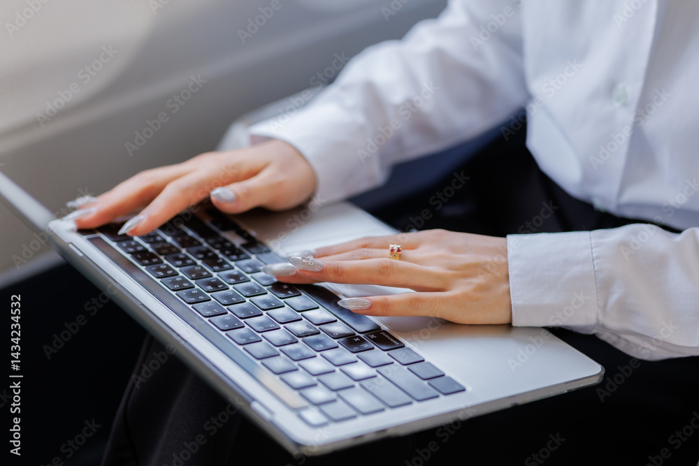 A determined businesswoman sits on a flight, visibly stressed as she rushes to polish her report before the plane touches down A determined businesswoman sits on a flight, visibly stressed as she rushes to polish her report before the plane touches down
