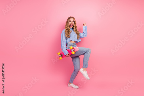 Obraz na płótnie Cheerful female holding vibrant skateboard against pink backdrop, expressing youthfulness and trendy lifestyle w salonie