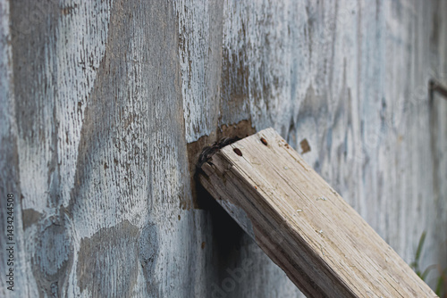 4x4 plank reinforcing a wall or bracing for a storm abstract concept for business, leadership, or extreme weather. design element, banner, or macro close-up background photo