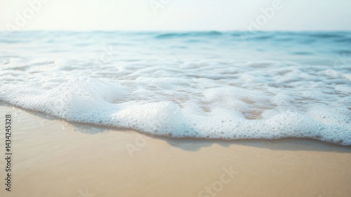Gentle ocean waves lapping on the sandy beach, tranquil scene evoking relaxation and natural beauty, perfect for serene backgrounds.