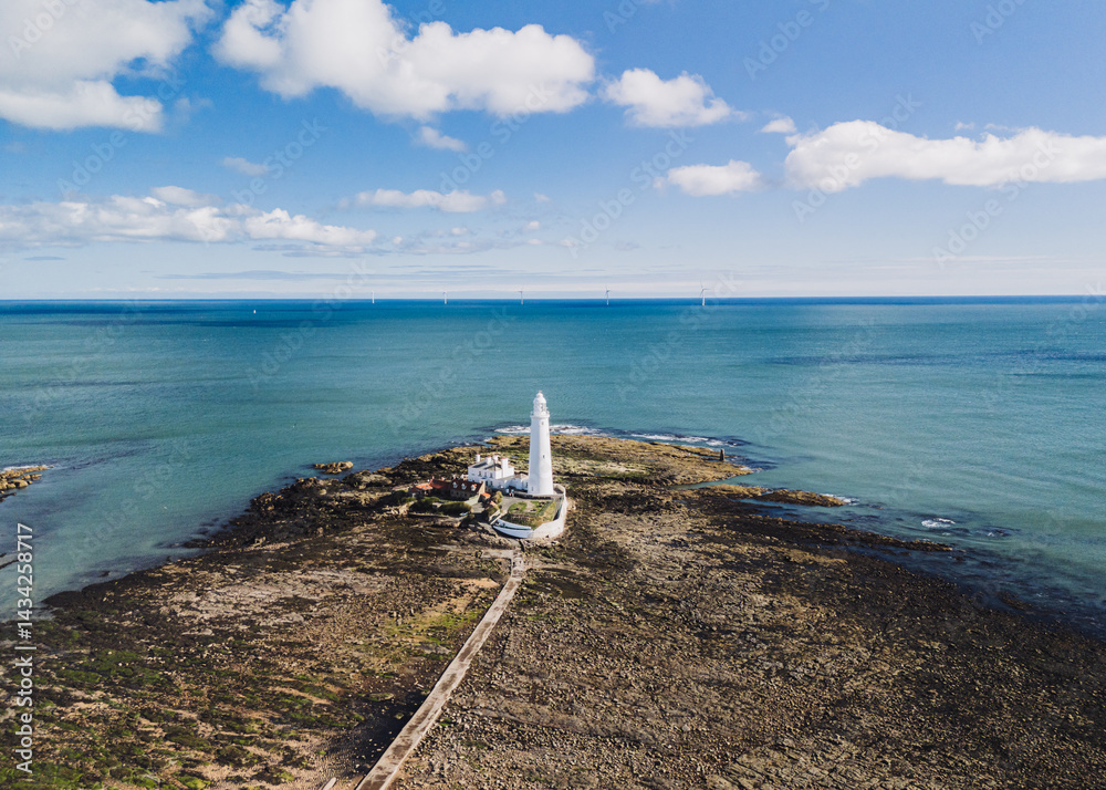 Whitley Bay UK: 13th April 2025: St Mary's Lighthouse is highlighted in this impressive aerial view, showcasing its structure against the tranquil waters of Whitley Bay on a clear day