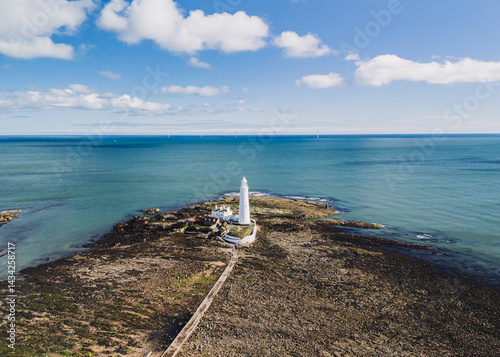 Obraz na płótnie Whitley Bay UK: 13th April 2025: St Mary's Lighthouse is highlighted in this impressive aerial view, showcasing its structure against the tranquil waters of Whitley Bay on a clear day w salonie