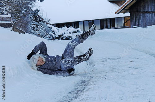 Rutschgefahr auf einer glatten Gehweg im Winter. Eine Frau ist auf dem Eis ausgerutscht und hingefallen